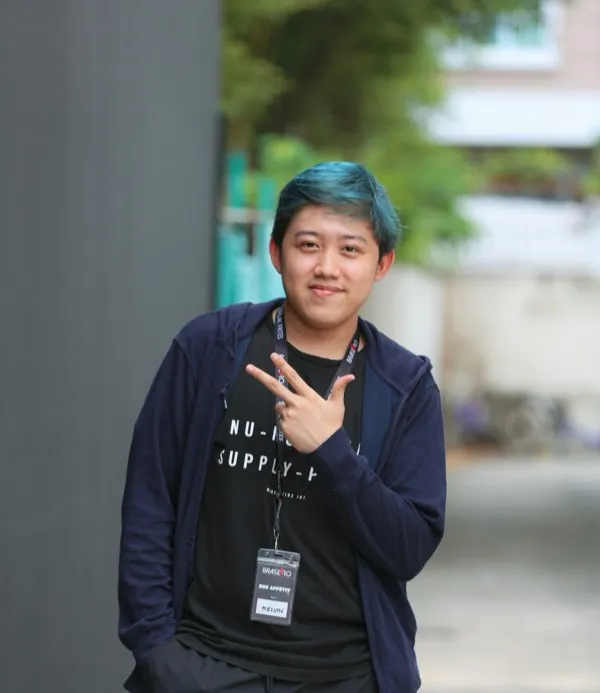 Young person smiling and making a peace sign
